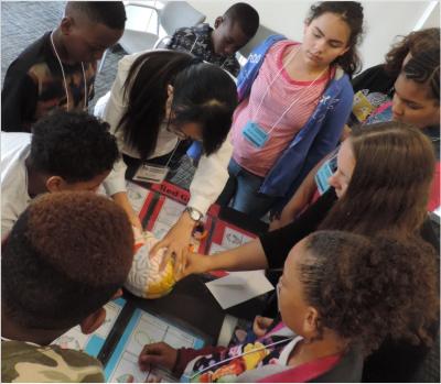 Students gather around a model of the brain